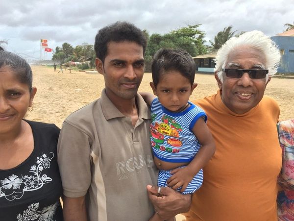 A family standing together on the beach with the author's father