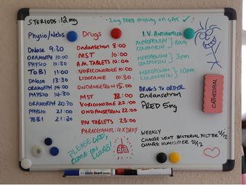 A hospital whiteboard listing medication times and daily care notes